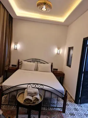 a bedroom with a bed and a table with towels on it at Riad Dar Fatna in Marrakech