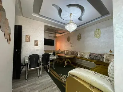 a living room with a couch and a table and chairs at Plaza sejour in Marrakech