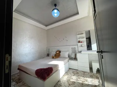 a bedroom with a bed with a teddy bear sitting on it at Plaza sejour in Marrakech