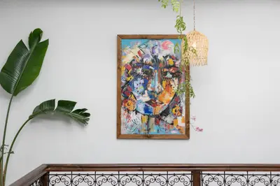 a painting hanging on a wall next to a plant at Riad Lamalika in Marrakech