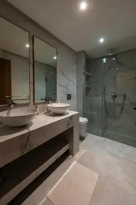 a bathroom with two sinks and a shower at Menara Garden duplex 3 suites in Marrakech