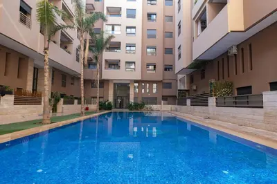 an empty swimming pool in front of a building at Menara Garden duplex 3 suites in Marrakech