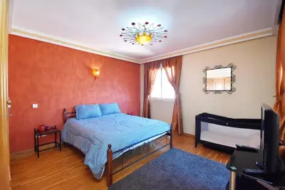 a bedroom with a bed and a television at Appartement au Coeur de quartier Majorelle in Marrakech