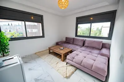 a living room with a purple couch and a table at Jawhar Appart in Marrakech