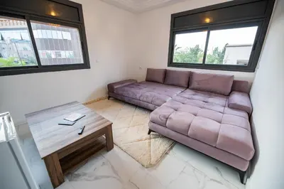 a living room with a couch and a table at Jawhar Appart in Marrakech