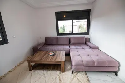 a living room with a purple couch and a table at Jawhar Appart in Marrakech