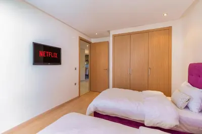 a bedroom with two beds and a tv on the wall at 2 Bedrooms Equipped apart in Marrakech