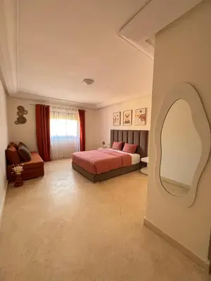 a bedroom with a bed and a large mirror at Appartement Piscine à Marrakech in Marrakech