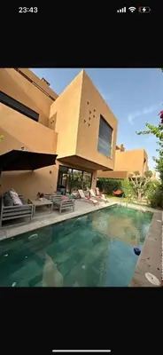 a house with a swimming pool in front of a building at Villa familiale avec piscine chauffée La Dolce Vita in Marrakech