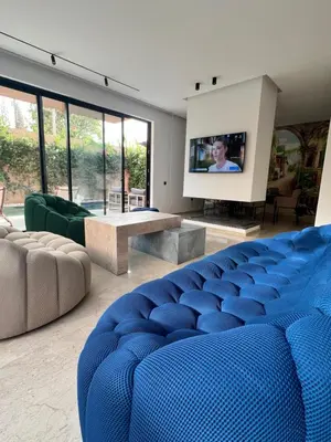 a living room with a blue couch and a tv at Villa familiale avec piscine chauffée La Dolce Vita in Marrakech