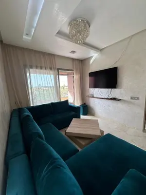 a living room with a blue couch and a table at l'écrin de prestigia agate studio in Marrakech