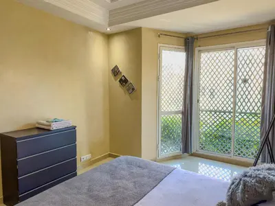 a bedroom with a bed and a large window at Rare ! duplex avec vue sur les toits de Marrakech in Marrakech