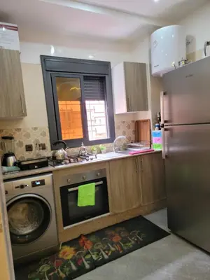 a kitchen with a refrigerator and a sink and a dishwasher at Appartement racha in Marrakech
