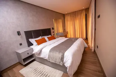 a bedroom with a large bed with orange pillows at Élégance et Prestige à Gueliz Appartement 3 chambres in Marrakech