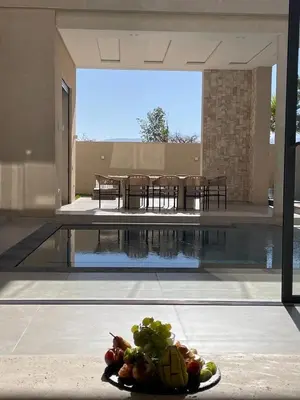 a plate of fruit next to a swimming pool at Villa Kenza piscine et jacuzzi chauffée in Marrakech