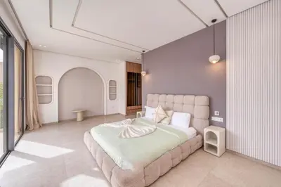 a bedroom with a large bed in a room at Villa Kenza piscine et jacuzzi chauffée in Marrakech