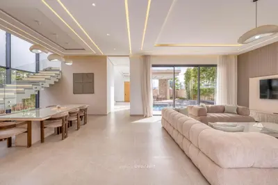 a living room with a long couch and a table at Villa Kenza piscine et jacuzzi chauffée in Marrakech