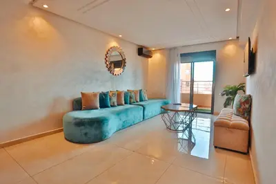 a living room with a blue couch and a table at Best Apartment Marrakech G35 in Marrakech