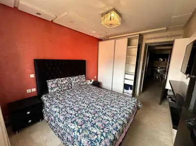 a bedroom with a bed and a red wall at Stylish & Comfy Appartment Haven 5 Stars Location Plaza Views in Marrakech