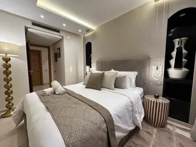 a bedroom with a large bed with white sheets and pillows at Luxury 2-Bedroom Apartment in City Center Jacuzzi & Heated Pool in Marrakech