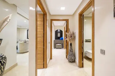 a hallway leading to a bathroom with a mirror at Luxury 2-Bedroom Apartment in City Center Jacuzzi & Heated Pool in Marrakech