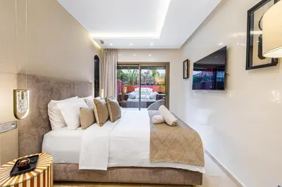 a bedroom with a large bed with white sheets and pillows at Luxury 2-Bedroom Apartment in City Center Jacuzzi & Heated Pool in Marrakech