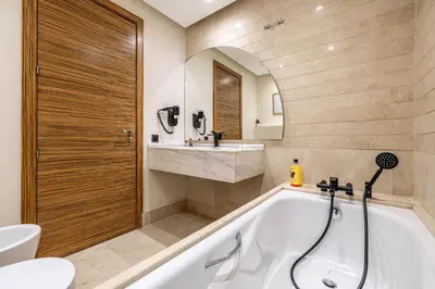 a bathroom with a tub and a toilet and a sink at Luxury 2-Bedroom Apartment in City Center Jacuzzi & Heated Pool in Marrakech