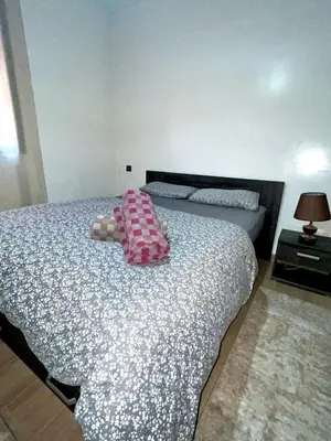 a bedroom with a bed with a pink pillow on it at Appartement de luxe à Marrakech in Marrakech