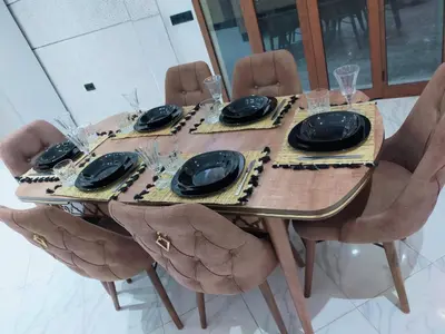 a wooden table with chairs and plates and glasses at Villa fahloui in Marrakech