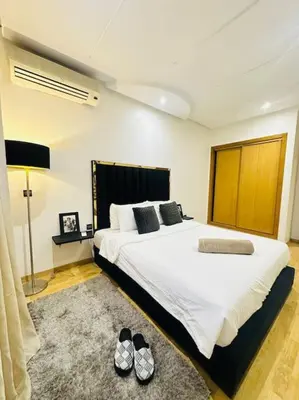 a bedroom with a large bed with shoes on the floor at Cosy House Marrakech Semlalia - Gueliz Center in Marrakech