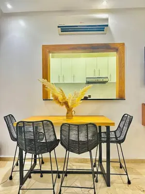 a table with chairs and a vase with a plant on it at Cosy House Marrakech Semlalia - Gueliz Center in Marrakech