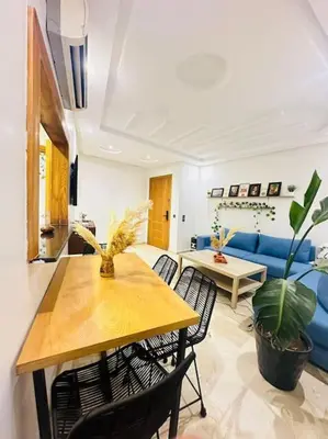 a living room with a table and a blue couch at Cosy House Marrakech Semlalia - Gueliz Center in Marrakech