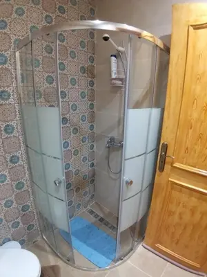 a shower with a glass door in a bathroom at Sweet home in Marrakech