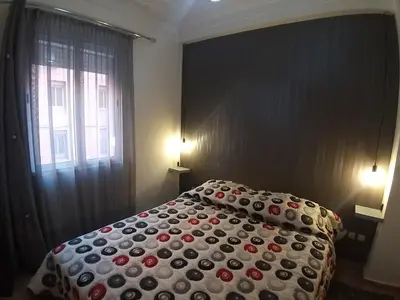 a bedroom with a large bed with a red and white comforter at Sweet home in Marrakech