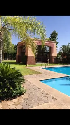 a house with a swimming pool and a palm tree at مراكش in Marrakech