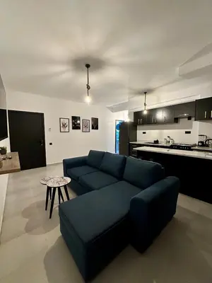 a living room with a blue couch and a kitchen at Luxury Appartement Marjane in Marrakech