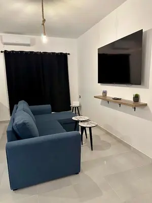 a living room with a blue couch and a tv at Luxury Appartement Marjane in Marrakech
