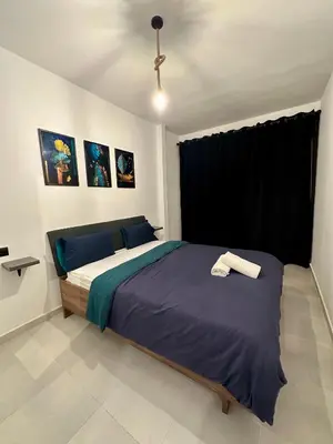 a bedroom with a large bed with a blue blanket at Luxury Appartement Marjane in Marrakech