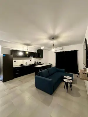 a living room with a blue couch and a kitchen at Luxury Appartement Marjane in Marrakech