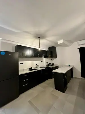 a kitchen with black cabinets and white counter tops at Luxury Appartement Marjane in Marrakech