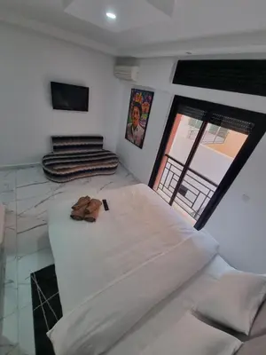 a room with a large white bed and a window at Kech vacations FRIENDLY! 2 bedroom luxury apartment in Marrakech