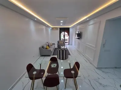a living room with a glass table and chairs at Kech vacations FRIENDLY! 2 bedroom luxury apartment in Marrakech