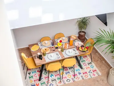 a table with food on it with yellow chairs at Riad Melina Au Coeur de la Medina Petit Dejeuner in Marrakech