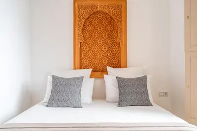 a bedroom with a bed with white sheets and pillows at Riad Melina Au Coeur de la Medina Petit Dejeuner in Marrakech