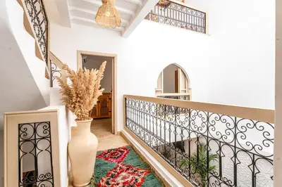 a hallway with a staircase with a vase at Riad Melina Au Coeur de la Medina Petit Dejeuner in Marrakech