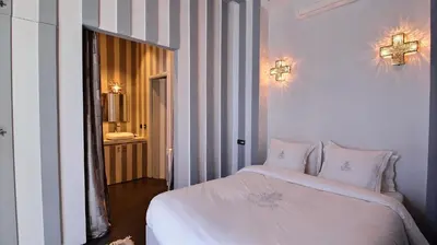 a bedroom with a white bed and a cross on the wall at Riad Goloboy in Marrakech