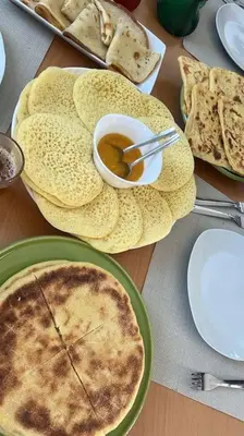 a table with plates of food and a bowl of soup at Villa Piscine Sans Vis à Vis in Marrakech