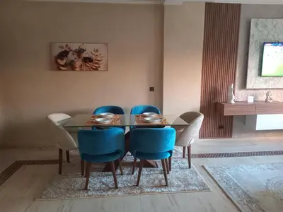 a dining room with a table and blue chairs at Luxury Apartment with swimming pool in Gueliz Marrakech in Marrakech