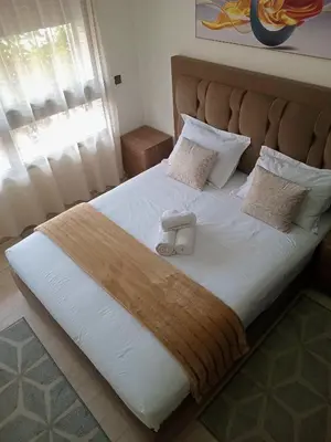a bed with a pair of shoes sitting on it at Luxury Apartment with swimming pool in Gueliz Marrakech in Marrakech