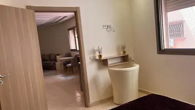 a bathroom with a door leading to a living room at Appartement de haute standing in Marrakech